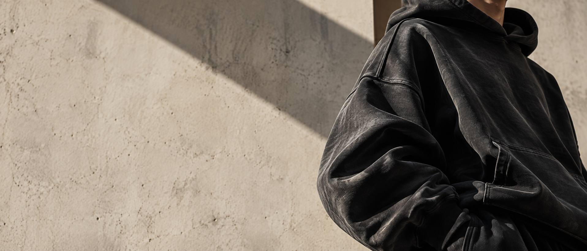 Rukáv Still Hoodie u betonové zdi