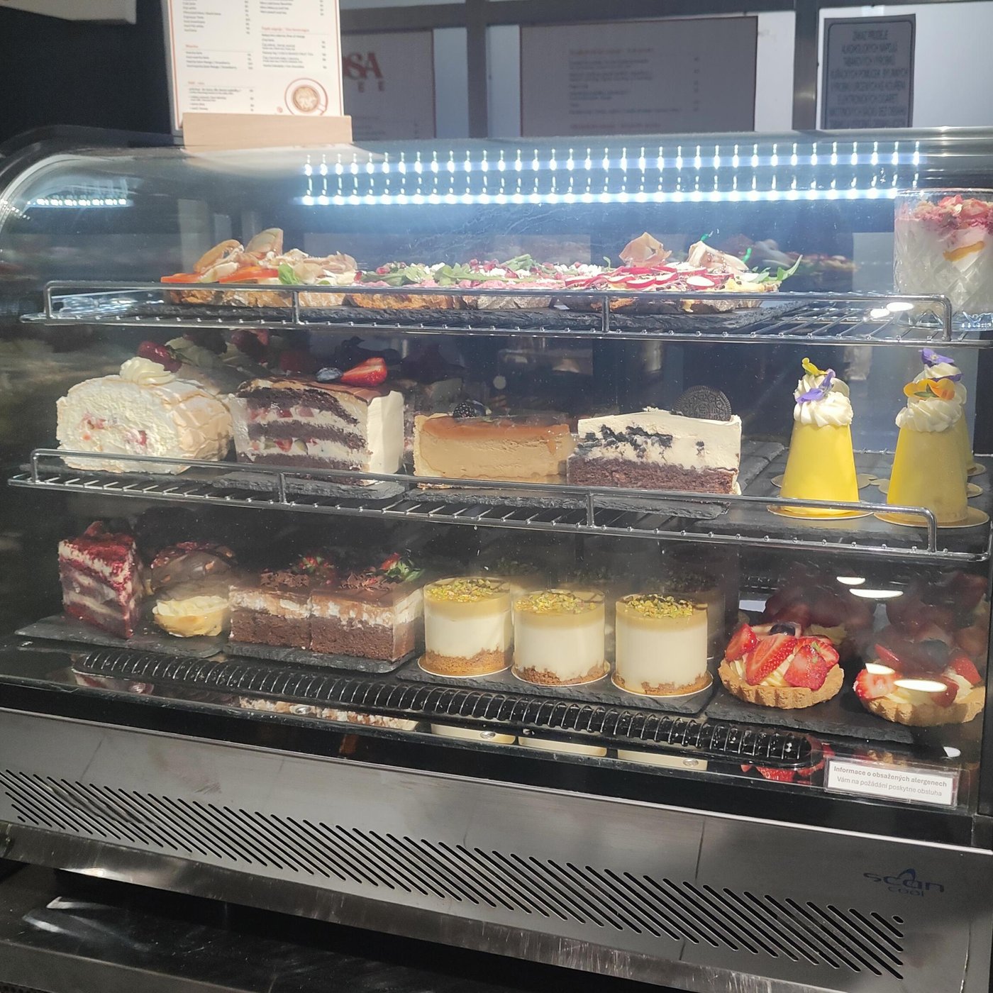 Chlazená vitrína plná dortů, cheesecaků a tartaletek